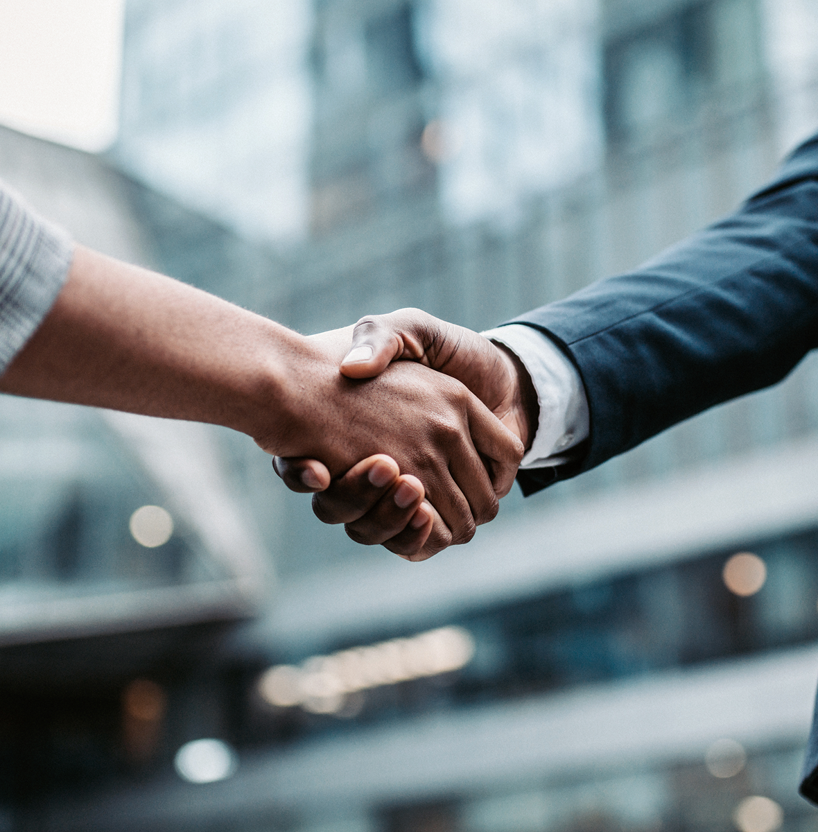 Two people shaking hands outside