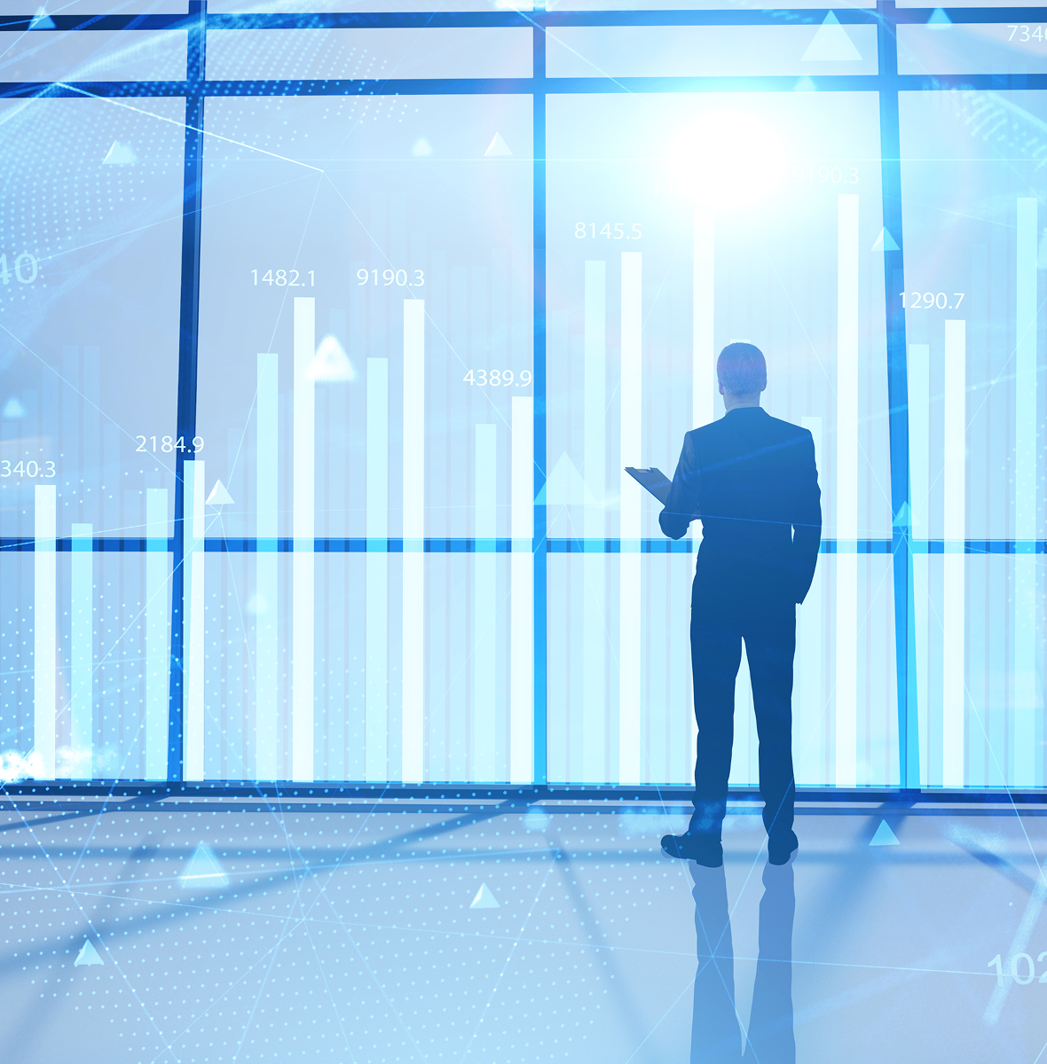 Man standing before digital stock graph